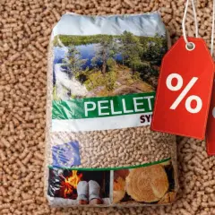 Worek pelletu Sylva Pomorskie na tle drobnych ziarenek. Dwa czerwone kupony z procentami sugerują promocję.