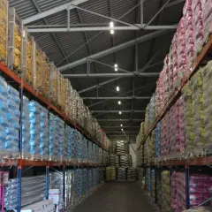 Magazyn Atex Pilchowice z ekogroszkiem i innymi produktami na paletach. Rzędy worków w foliowych opakowaniach.
