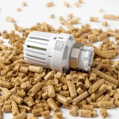 Termostat grzejnikowy leży na stercie premium selection pellets.