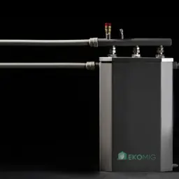 Nowoczesny kocioł indukcyjny CO Ekomig z przyłączami hydraulicznymi i zaworem bezpieczeństwa.