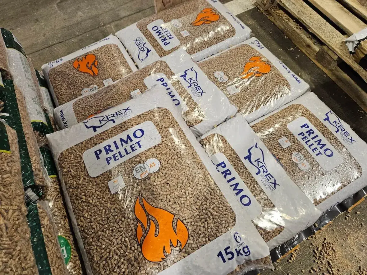 Workujesz nad tym, ile kosztuje pellet? Na zdjęciu worki PRIMO PELLET KREX, każdy po 15 kg, gotowe do ogrzania domu.