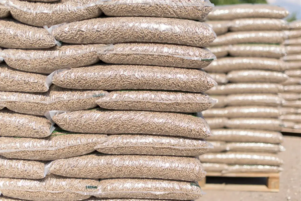 Stosy worków z pelletem drzewnym. Zastanawiasz się, ile kosztuje paleta pelletu? Oto odpowiedź w naturze.